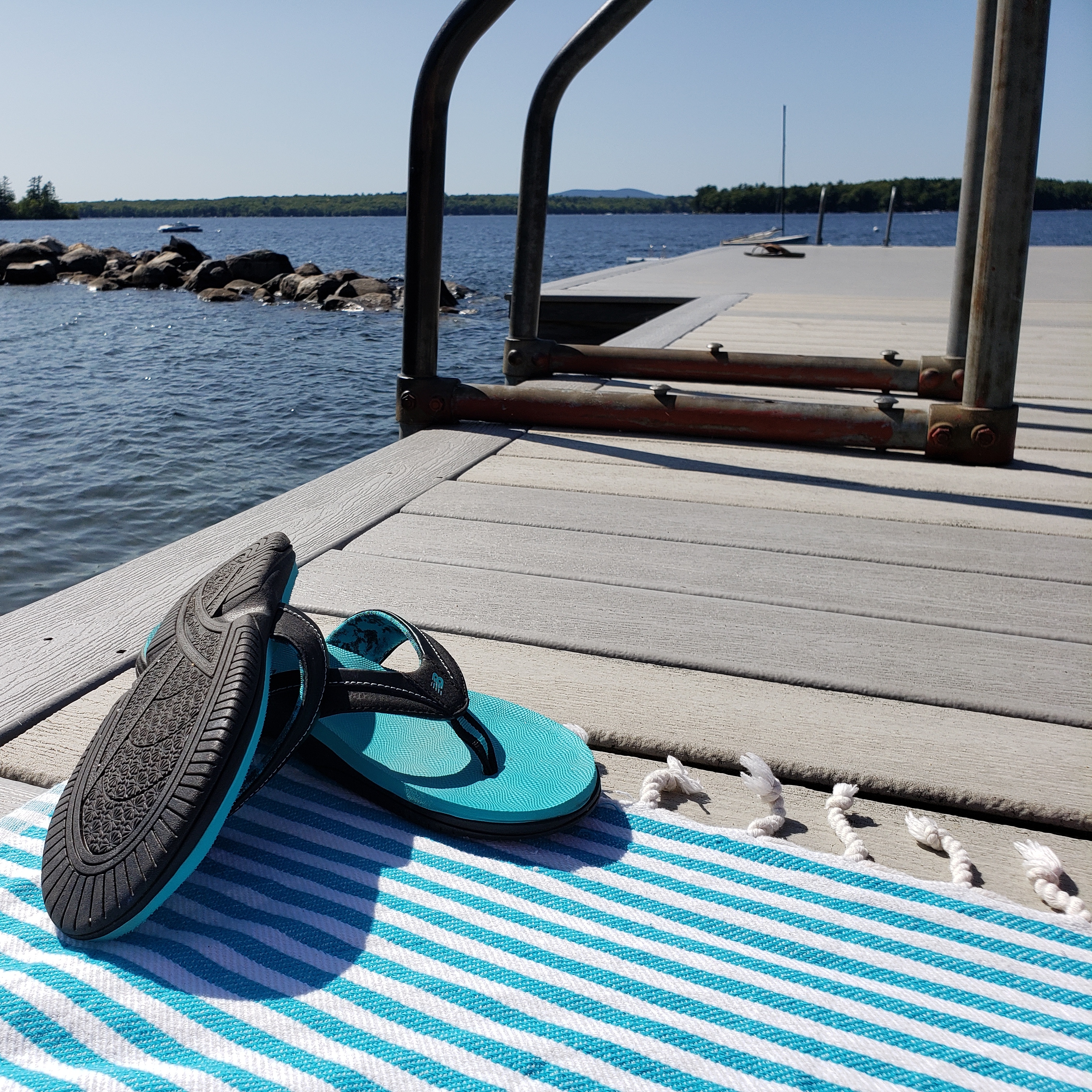 some sandals on a dock in maine, by a lake