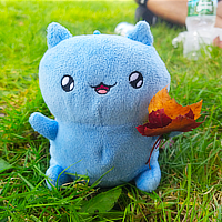 a stuffed animal (catbug) holding a leaf in the grass