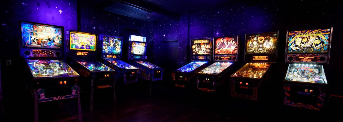 row of pinball games in an arcade