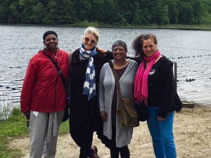 4 women standing in front of a lake