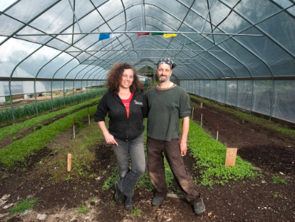 two people standing in a greehouse smiling
